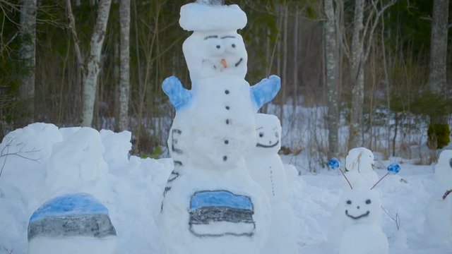 The big snowman with big eyes has a snow hat in color blue and hands in blue too.