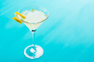 Yellow martini cocktail with lemon and mint on the rustic wooden background
