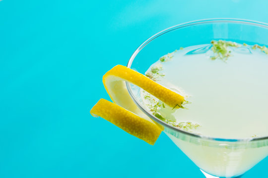 Yellow martini cocktail with lemon and mint on the rustic wooden background