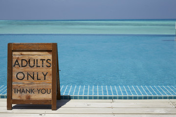 Adults only sign by an infinity pool with ocean beyond