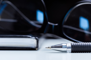 Notebook, pencil and glasses