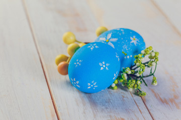 Easter eggs painted in pastel colors on white wooden background.