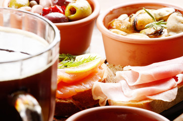 Tapas of salmon, mussels, jamon and olives with beer