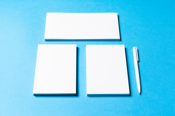 blank office objects organized for company presentation on blue paper background