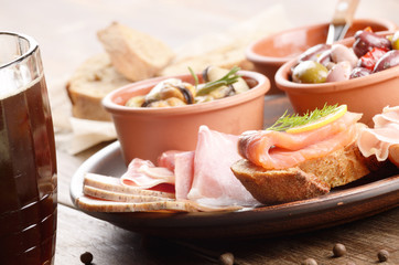 Tapas of salmon, mussels, jamon and olives with beer