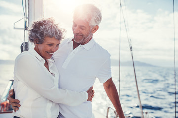 Romantic senior couple standing on sailboat