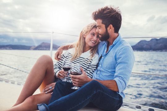 Romantic couple relaxing on yacht with red wine