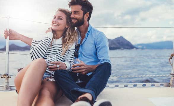 Romantic couple relaxing on yacht with red wine
