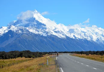 Crédence en verre imprimé Aoraki/Mount Cook Adventurous person riding a bike on the road to the mountains