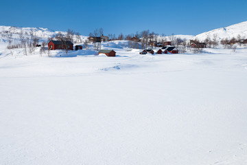 Rote Ferienhäuser in der weißen Winterlandschaft in Schweden