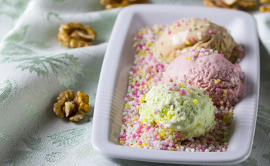 Different ice creams in a glass bowl with nuts
