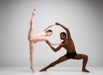 Obraz premium Couple of ballet dancers posing over gray background