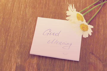 Naklejka premium Daisy flower and piece of paper with text 