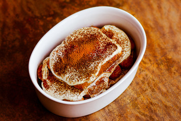 homemade tiramisu on a dark wooden background