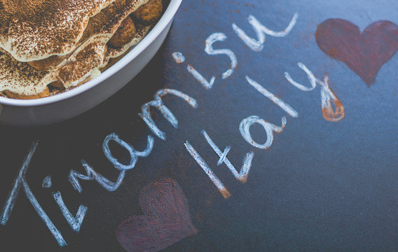 tiramisu with text on the blackboard I love you. toned image of an old rustic background