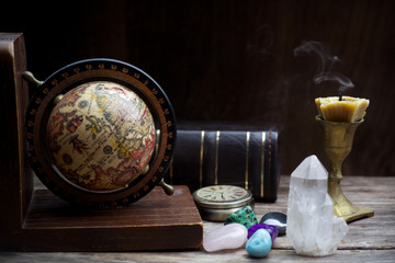 Ancient astrology. Old astrology globe and books with candle