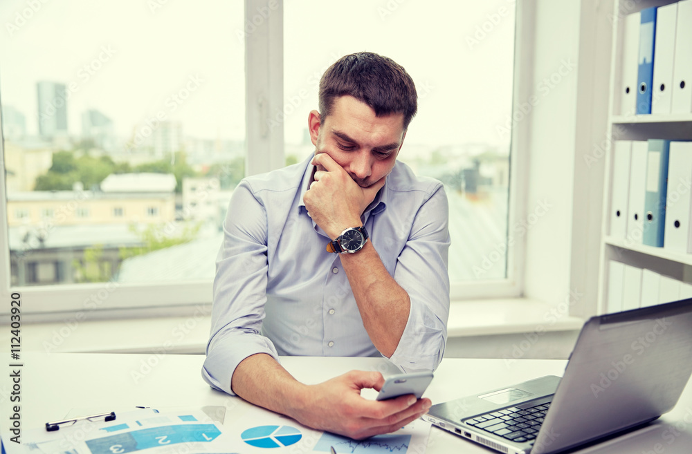 Wall mural businessman with smartphone and laptop at office