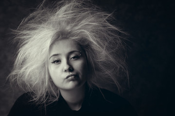 Portrait of annoyed girl with wild hair, photo in black and white. Tired woman with boring face.