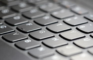 Closeup of computer keyboard keys with narrow focus and selectively blurred background