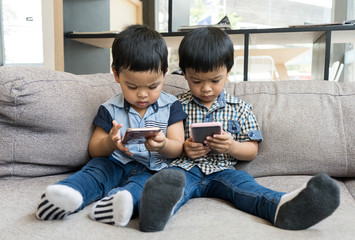 Young Asian boys play on smart phone