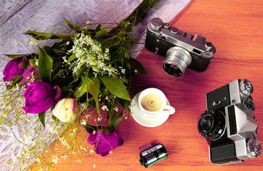 vintage camera near a bouquet of flowers and candles
