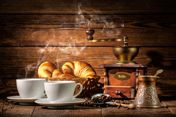 Coffee and croissants on wooden background