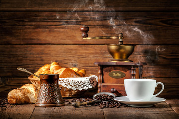Coffee and croissants on wooden background