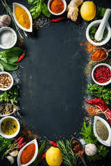 Herbs and spices over black stone background - obrazy, fototapety, plakaty