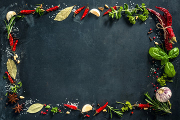 Herbs and spices over black stone background