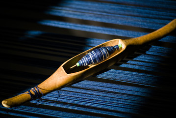 Wooden hand loom shuttle with blue thread
