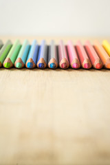 Obraz premium Color Pencils on wood texture. Macro shot of colorful pencils. Vertical view of pencils. Pencils in row.