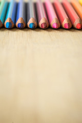 Obraz premium Color Pencils on wood texture. Macro shot of colorful pencils. Vertical view of pencils. Pencils in row.