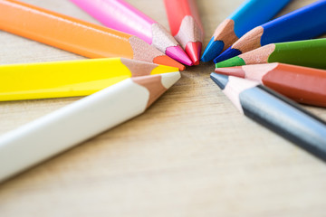 Fototapeta premium Color Pencils on wood texture. Macro shot of colorful pencils. Horizontal view of pencils. Selective focus.