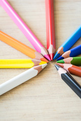 Fototapeta premium Color Pencils on wood texture. Macro shot of colorful pencils. Vertical view of pencils.