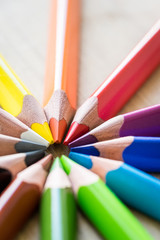 Obraz premium Color Pencils on wood texture. Macro shot of colorful pencils. Vertical view of pencils.