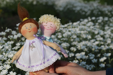 Textile toy doll little boy with small girl in hand