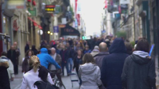 Unrecognizable crowd walking down the street, people enjoying weekend in city