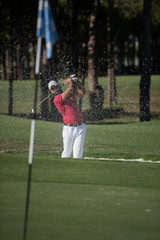 golfer hitting a sand bunker shot