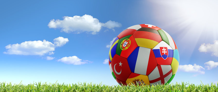 Fußball im Gras vor blauem Himmel mit Sonne und Wolken