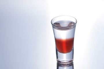 Colorful layered shot isolated on white gray gradient background with reflection. Alcohol shooter