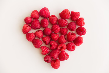 Juicy red heart made of organic fresh raspberries on white background. Healthy food for healthy life. Valentine's day