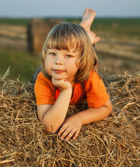 Naklejka na ściany i meble boy in a haystack in the field