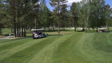 A group of people traveling by car on a Golf course - Powered by Adobe