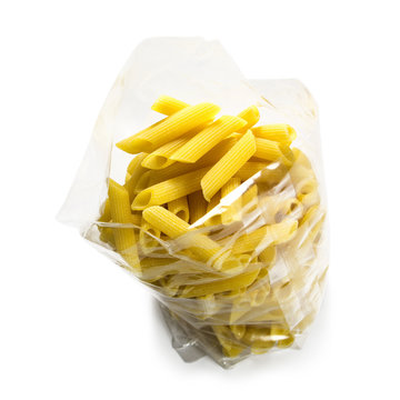 raw italian pasta penne in a transparent plastic bag from above, isolated on a white background