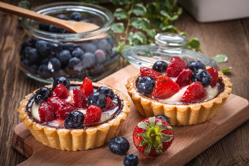 Fresh homemade fruit tart with strawberries and blueberries. - obrazy, fototapety, plakaty