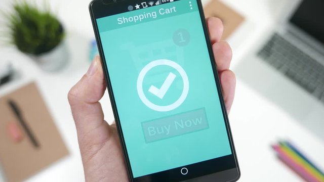 Pressing the Buy Now button to shop and pay a online store on smarrtphone.