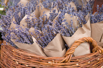 Top view on beutiful fresh lavender flowers in the basket on the street market. Bunches of lavender in craft paper. Romantic flowers.
