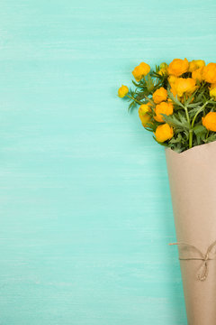 Bouquet Of Yellow Flowers On Turquoise Wooden Background. Top View On Birthday Bouquet. Flay Lay. Lifestyle And Holidays Concept.