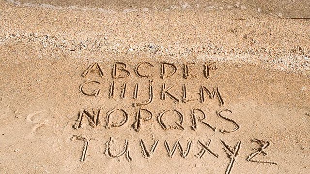 English Alphabet Written On A Beach Sand.