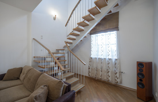 Two-storey studio apartment. Interior. A wooden staircase.